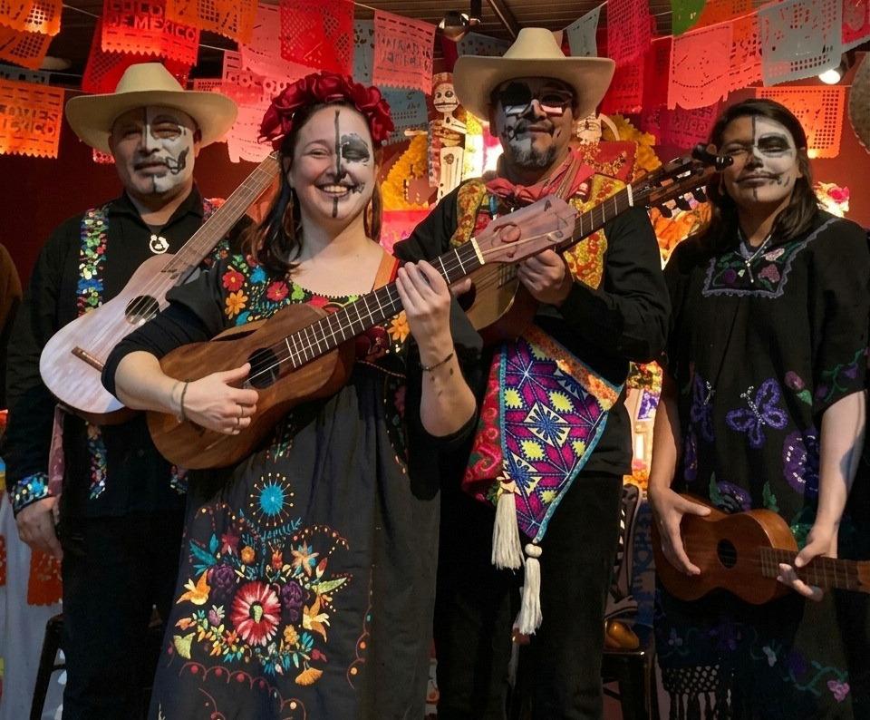 4 kleurrijk geschminkte muzikanten met gitaren, voor Día de los Muertos